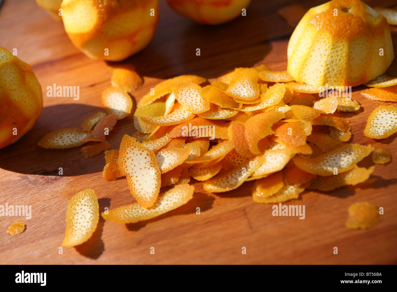 Pile of orange peel on a wooden chopping board, outside. Stock Photo