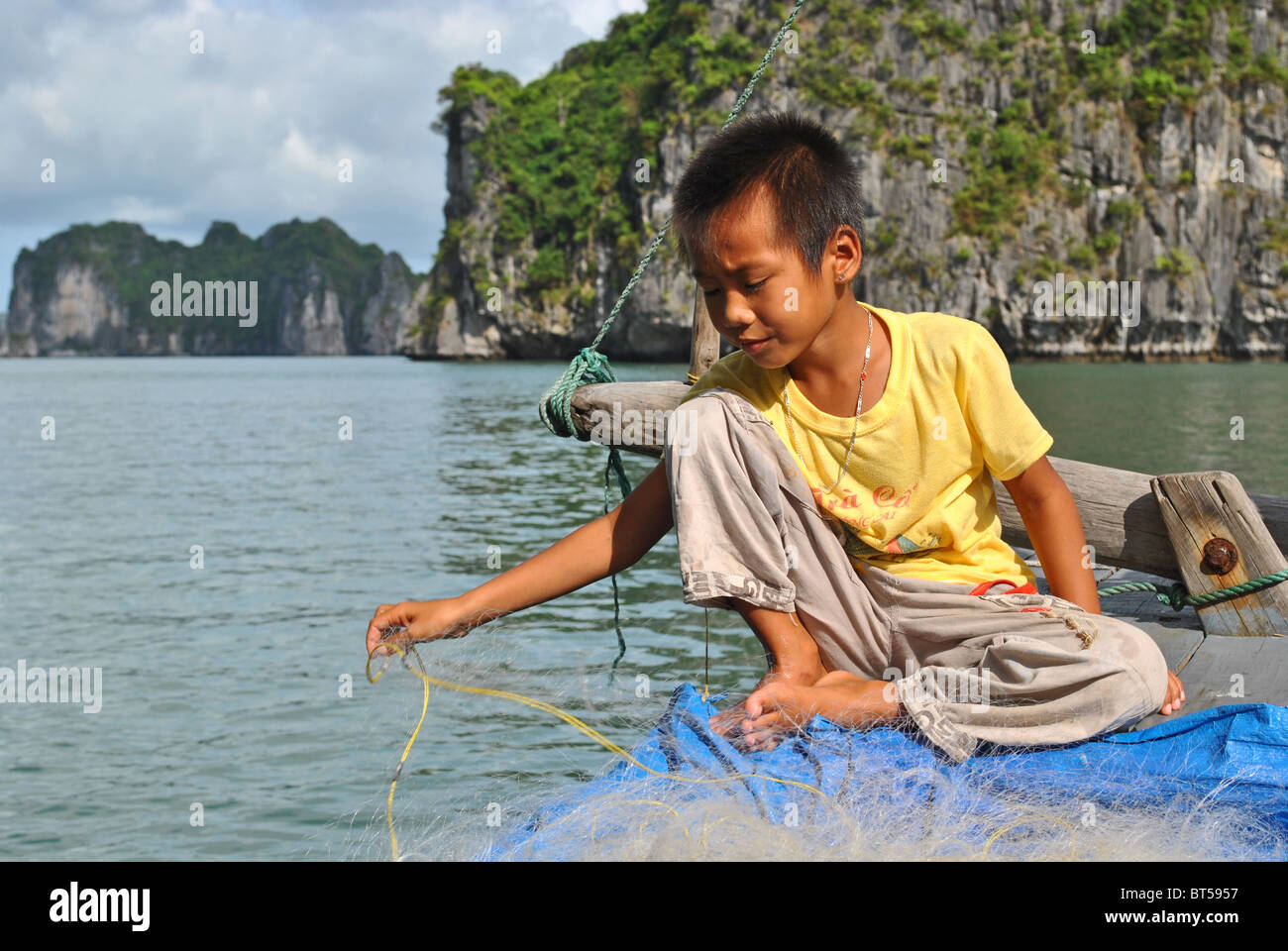 Child fishing in Ha Long Bay, Vietnam Stock Photo