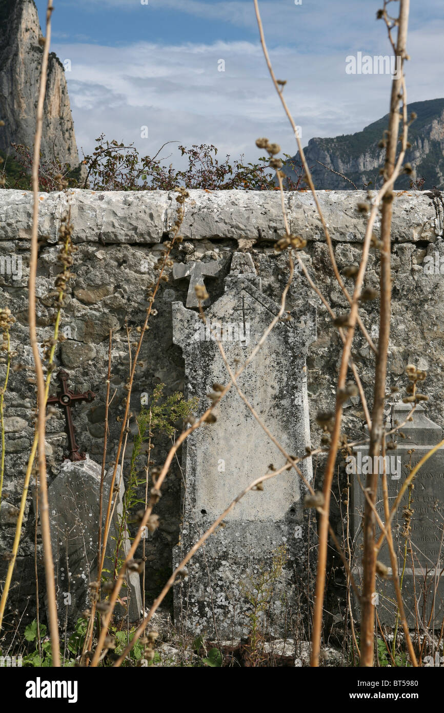 Tombstones leaning against a stone wall, Saou cemetery, Drôme, France. Stock Photo