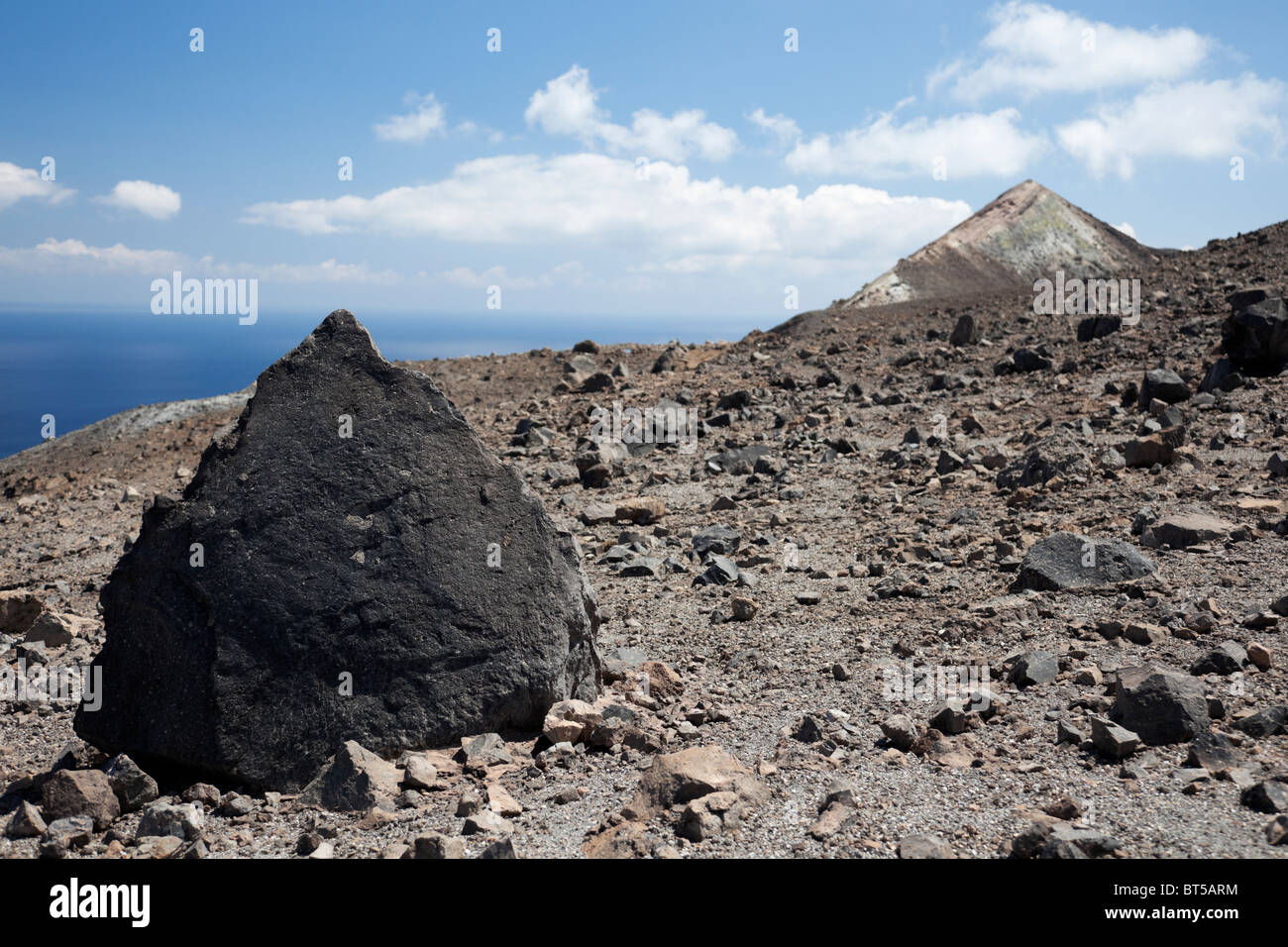 Large black volcanic rock on the top of the Gran Cratere of Vulcano Island of Aeolian Islands. Stock Photo