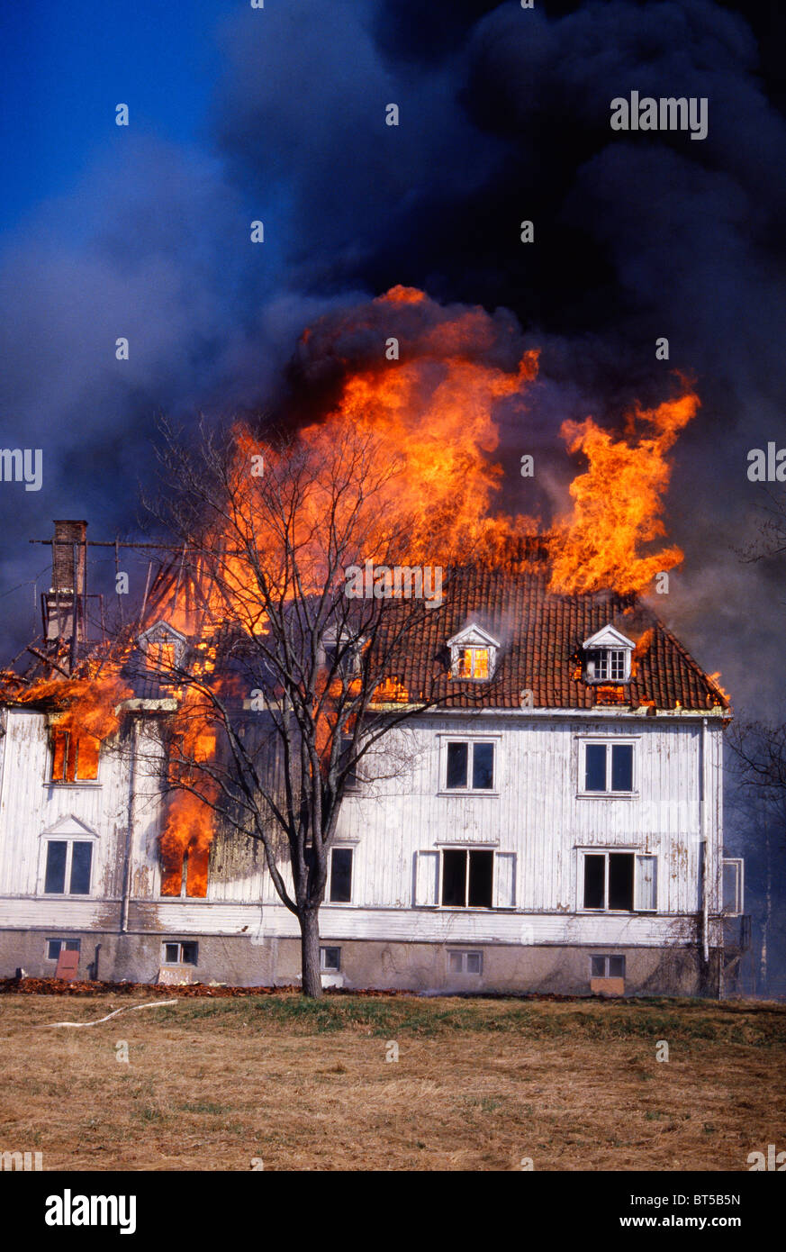 The old building is engulfed in flames as the fire moves rapidly. The fire claimed the house which was a total loss. Stock Photo