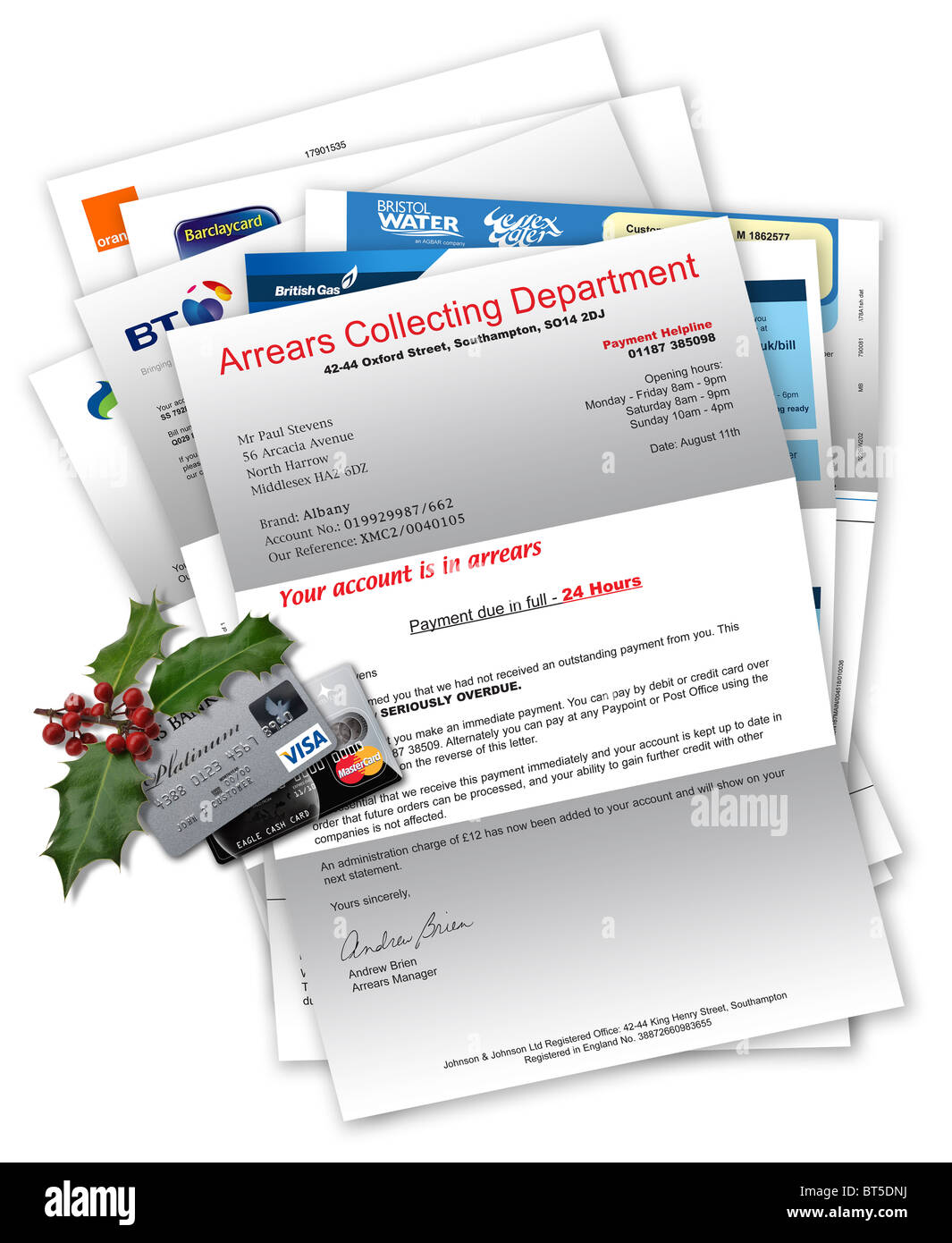 Collection agency letter with household bills beneath, credit cards and Christmas holly on top Stock Photo