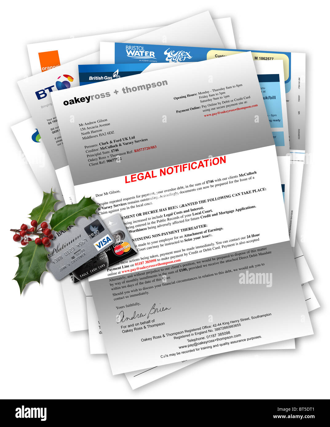 Legal Notification with household bills beneath, credit cards and Christmas holly on top Stock Photo