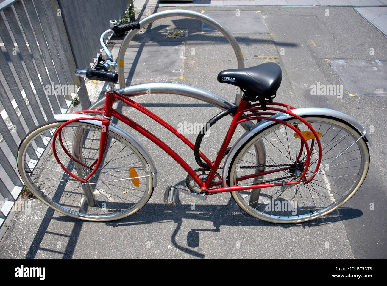 red bicycle with curved frame on curved railings Stock Photo Alamy