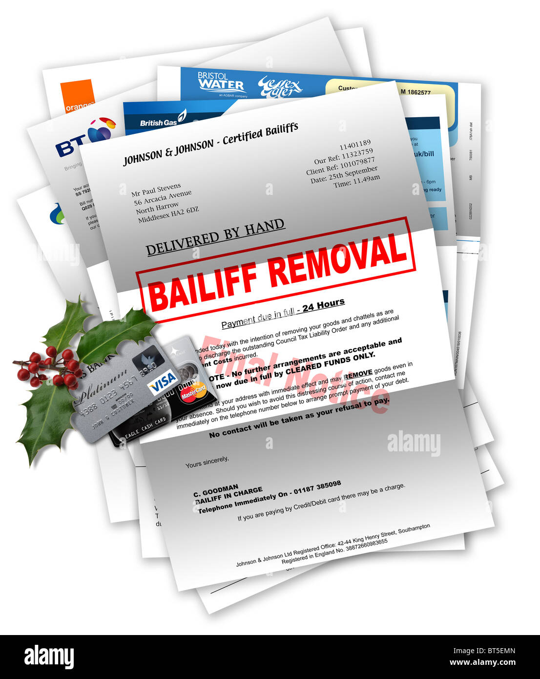 Bailiff letter with household bills beneath, and credit cards with Christmas holly on top Stock Photo