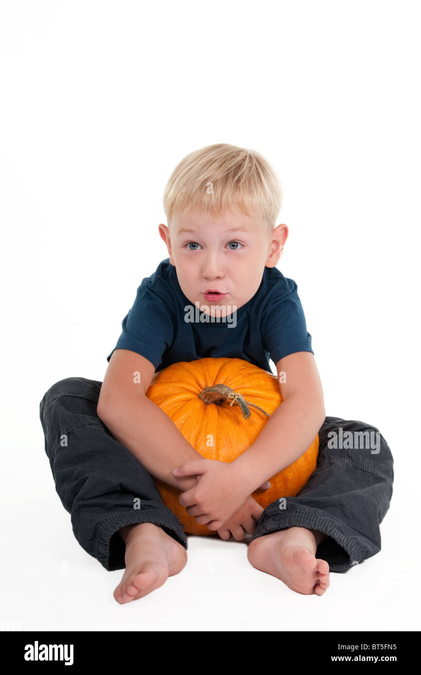 Young boy holding a pumpkin among his legs Stock Photo Alamy