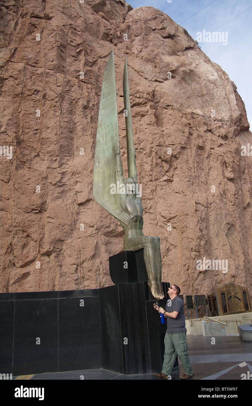 A man looks up at one of the winged, 30-foot tall statues at the Hoover Dam. Stock Photo