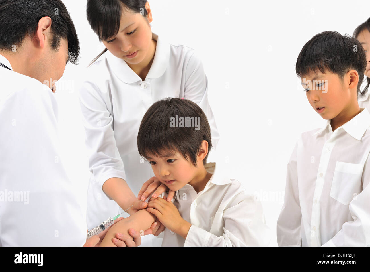 Male doctor and female nurse giving children injection Stock Photo