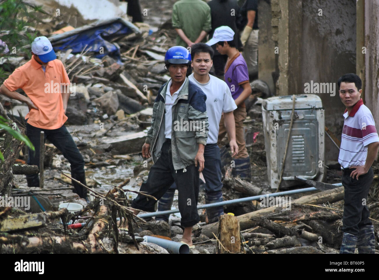 Workers clear debris from the scene of a mudslide triggered by heavy rain near Sapa, Vietnam Stock Photo
