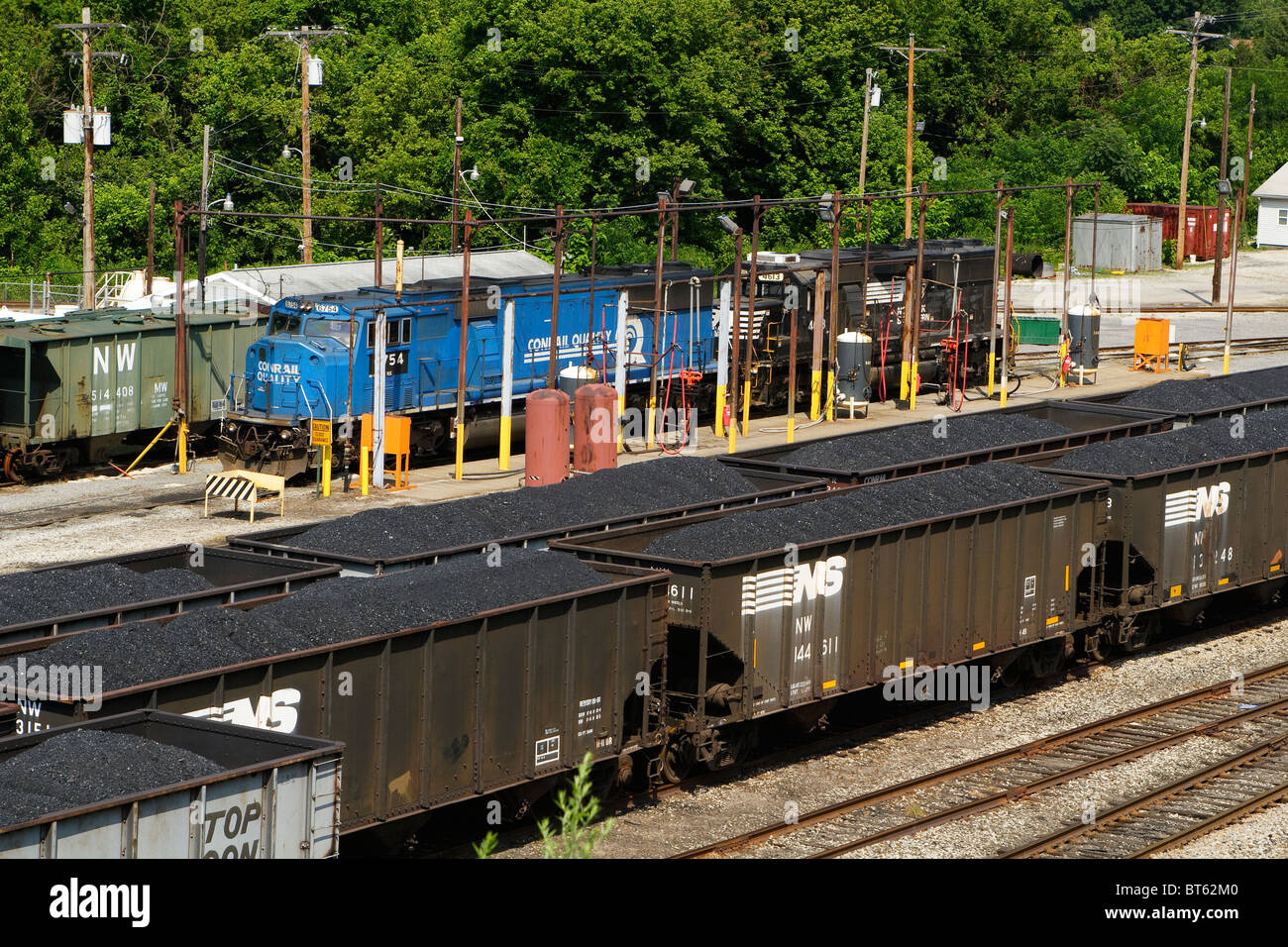 2 Norfolk Southern owned locomotives at a railroad yard fueling station in Dickinson, WV. Coal cars dominate the foreground. Stock Photo