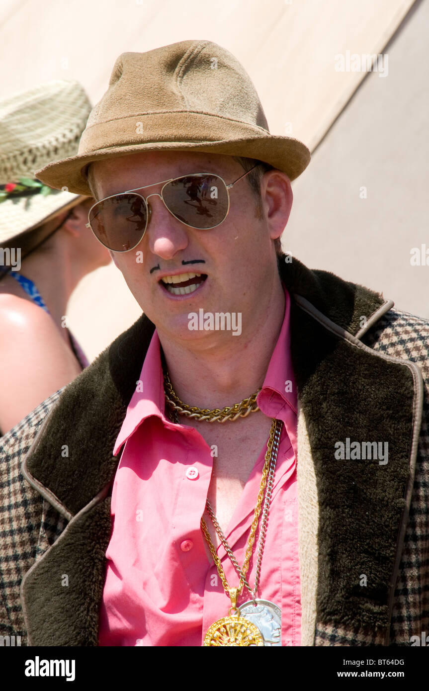 2010 Glastonbury Festival of Contemporary Performing Arts festival spiv del boy mol fur coat hat moustache cockney dealer trader Stock Photo