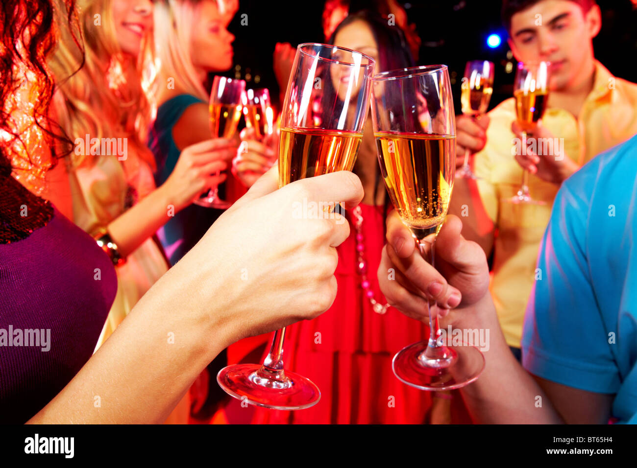 Image of toasting couple clinking glasses with champagne at party Stock