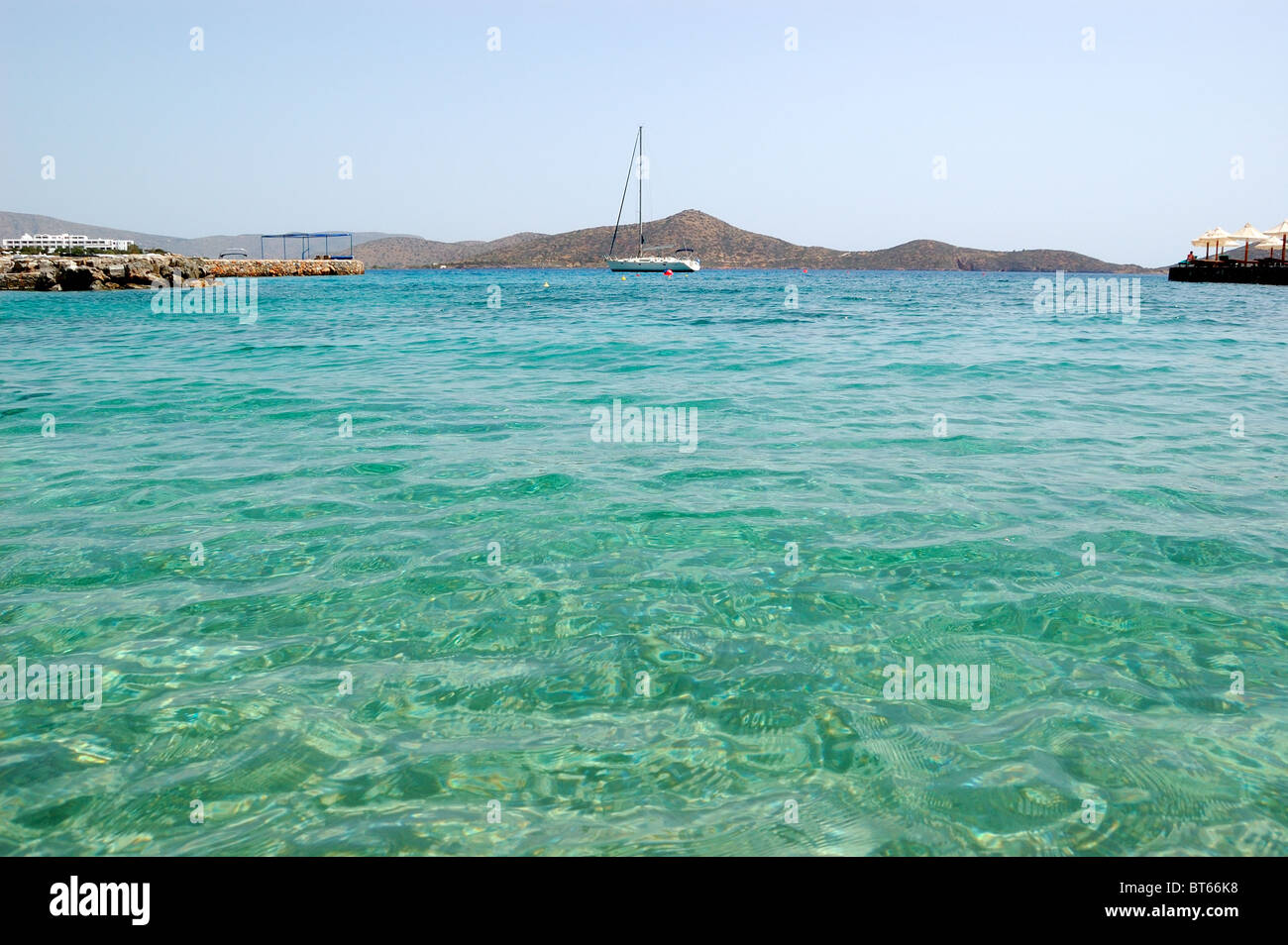 Turquoise Aegean Sea near beach of luxury hotel with yacht view, Crete, Greece Stock Photo