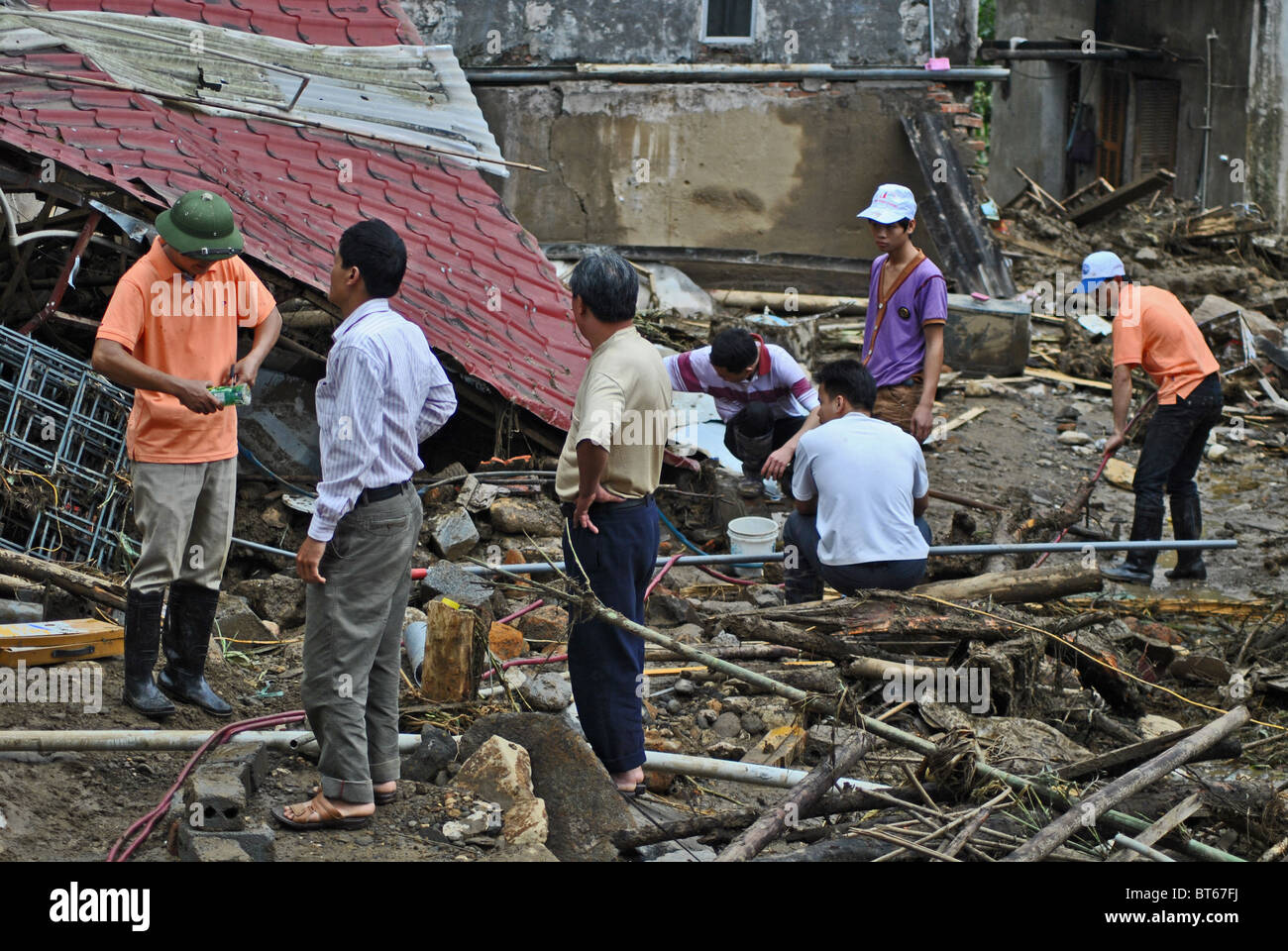 Collapsed house and workmen after a landslide triggered by heavy rain near Sapa, Northern Vietnam Stock Photo