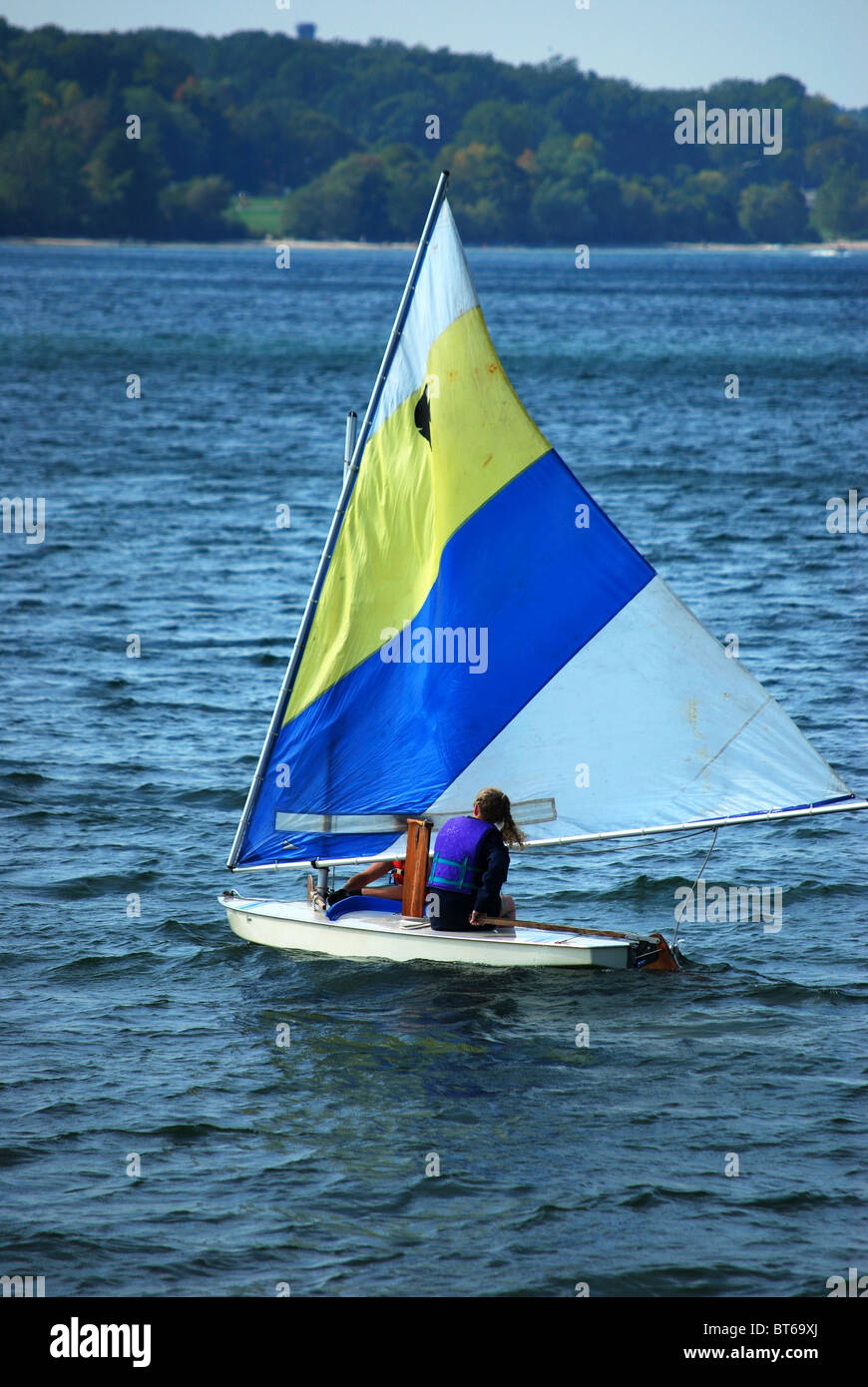 young couple and mini sail boat on blue water Stock Photo