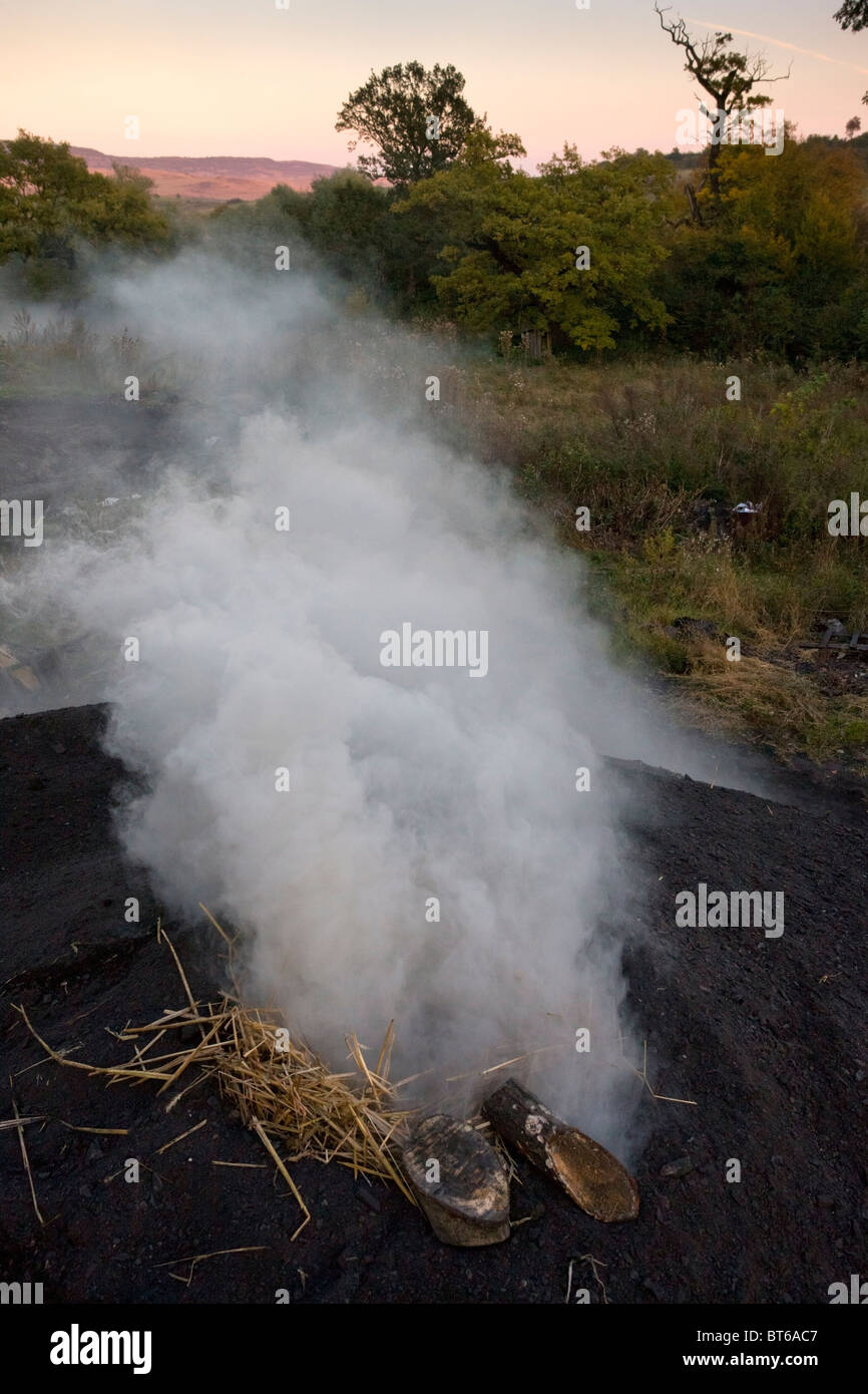 Newly-lit pile in the traditional charcoal-burner's yard at Viscri saxon village, Transylvania, Romania Stock Photo