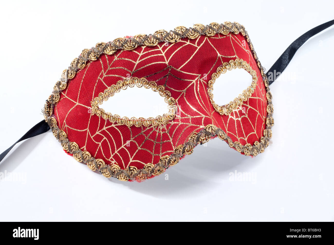 Decorative Masquerade Ball Mask With A Spiders Web Design In Red And Gold Stock Photo