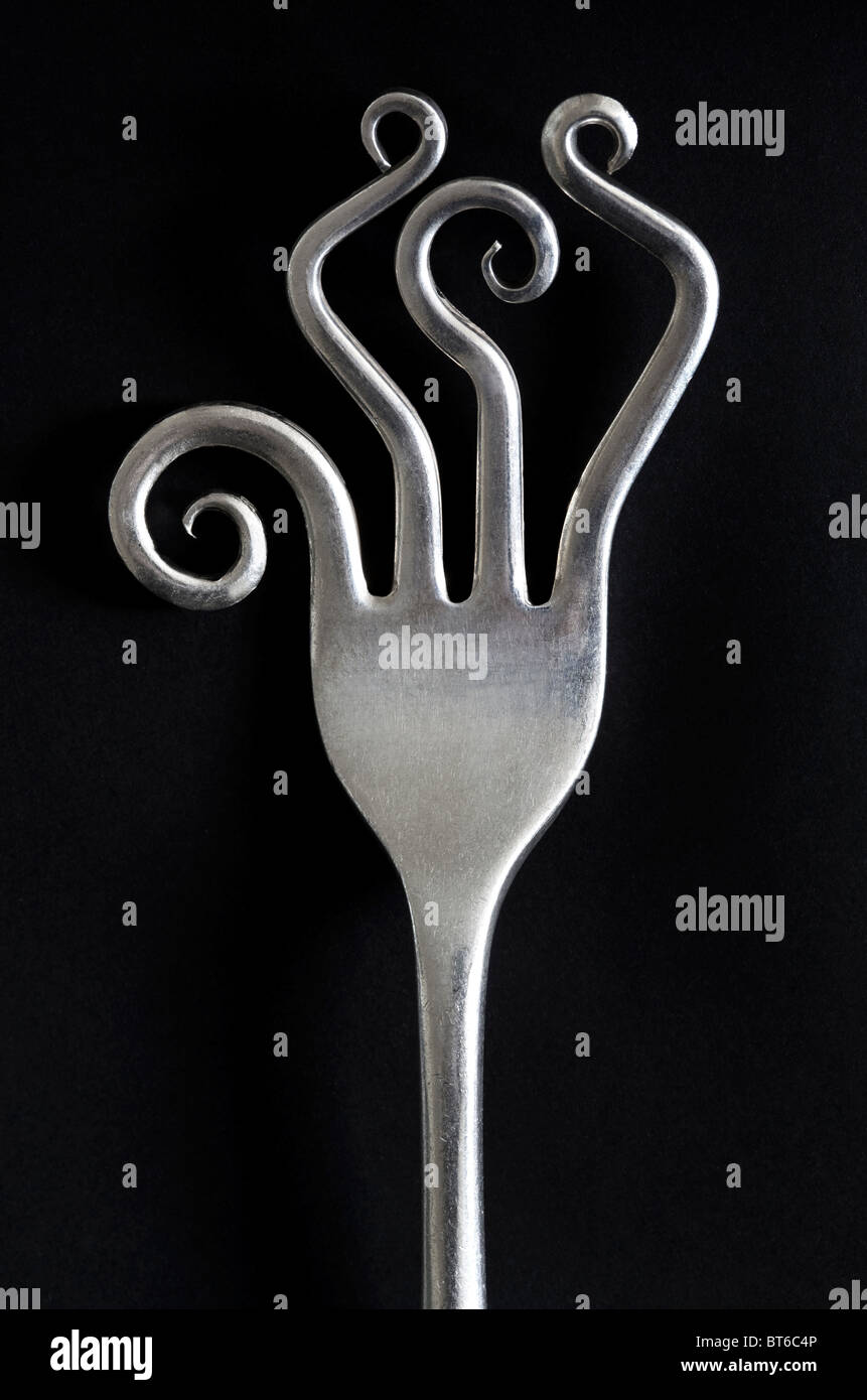 Close up of old vintage kitchen fork with wild curly prongs or tines Stock Photo