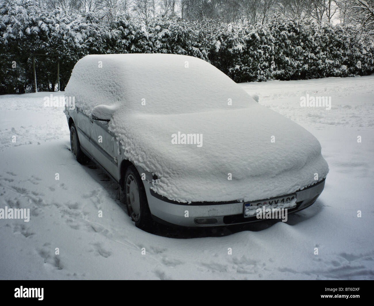 Volvo on a winterly parking lot hidden under a cover of snow. Stock Photo