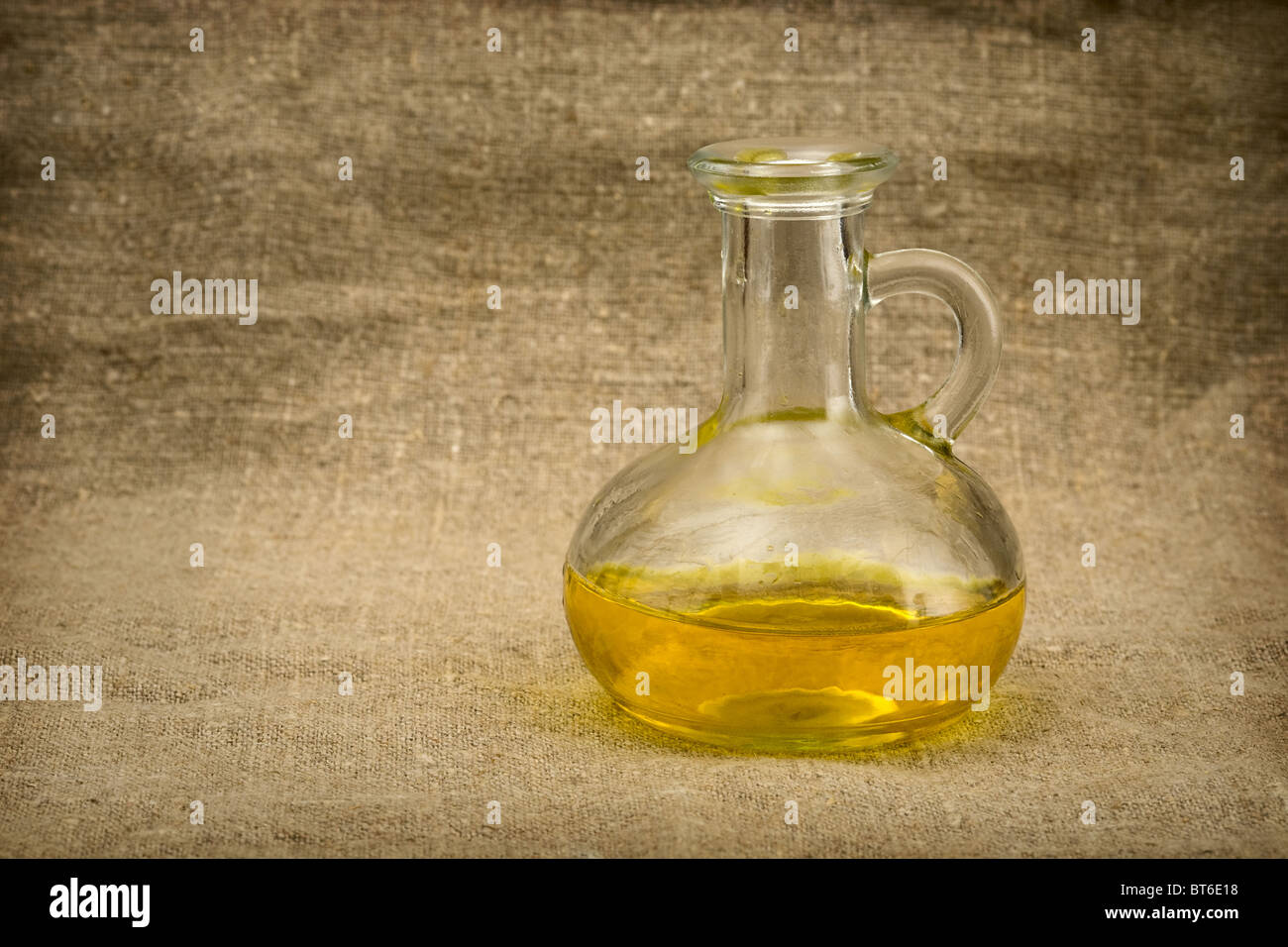 Carafe with yellow oil on canvas background Stock Photo