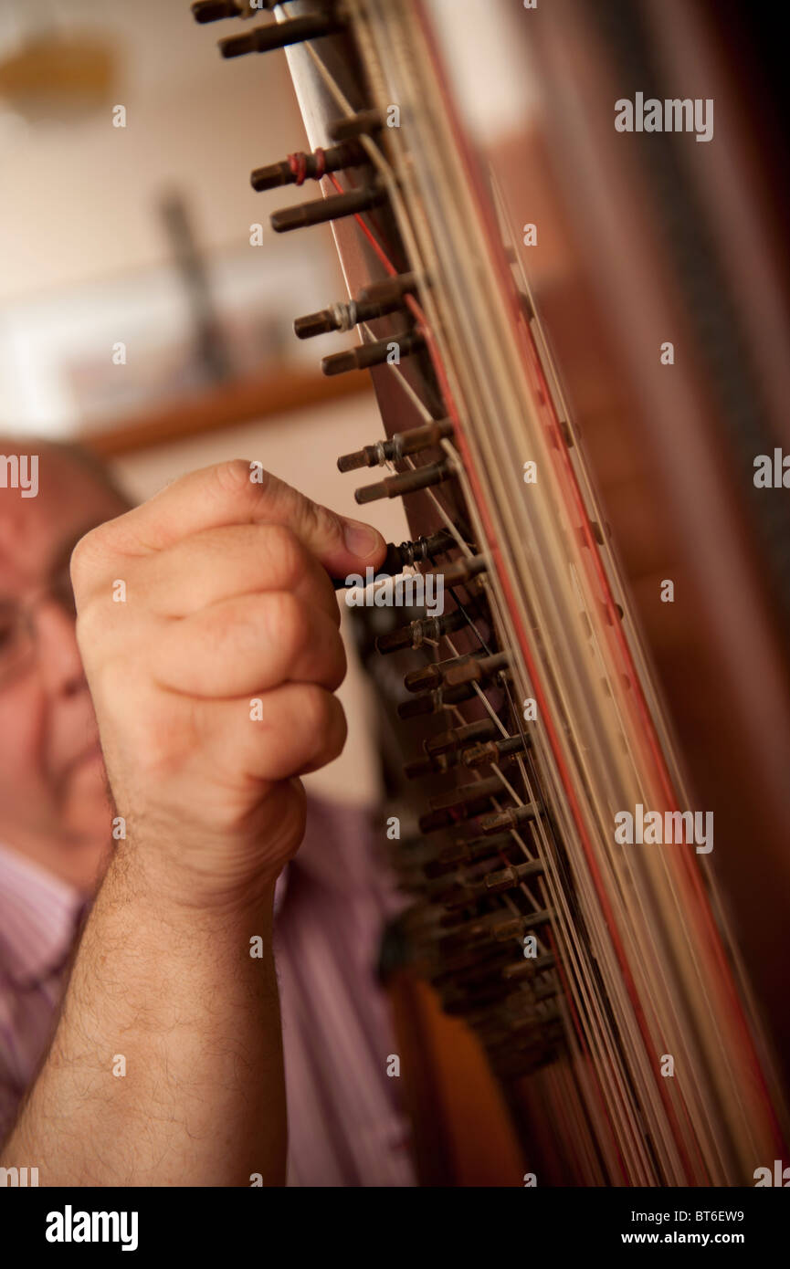 Welsh traditional harpist Robin Huw Bowen tuning his harp Stock Photo