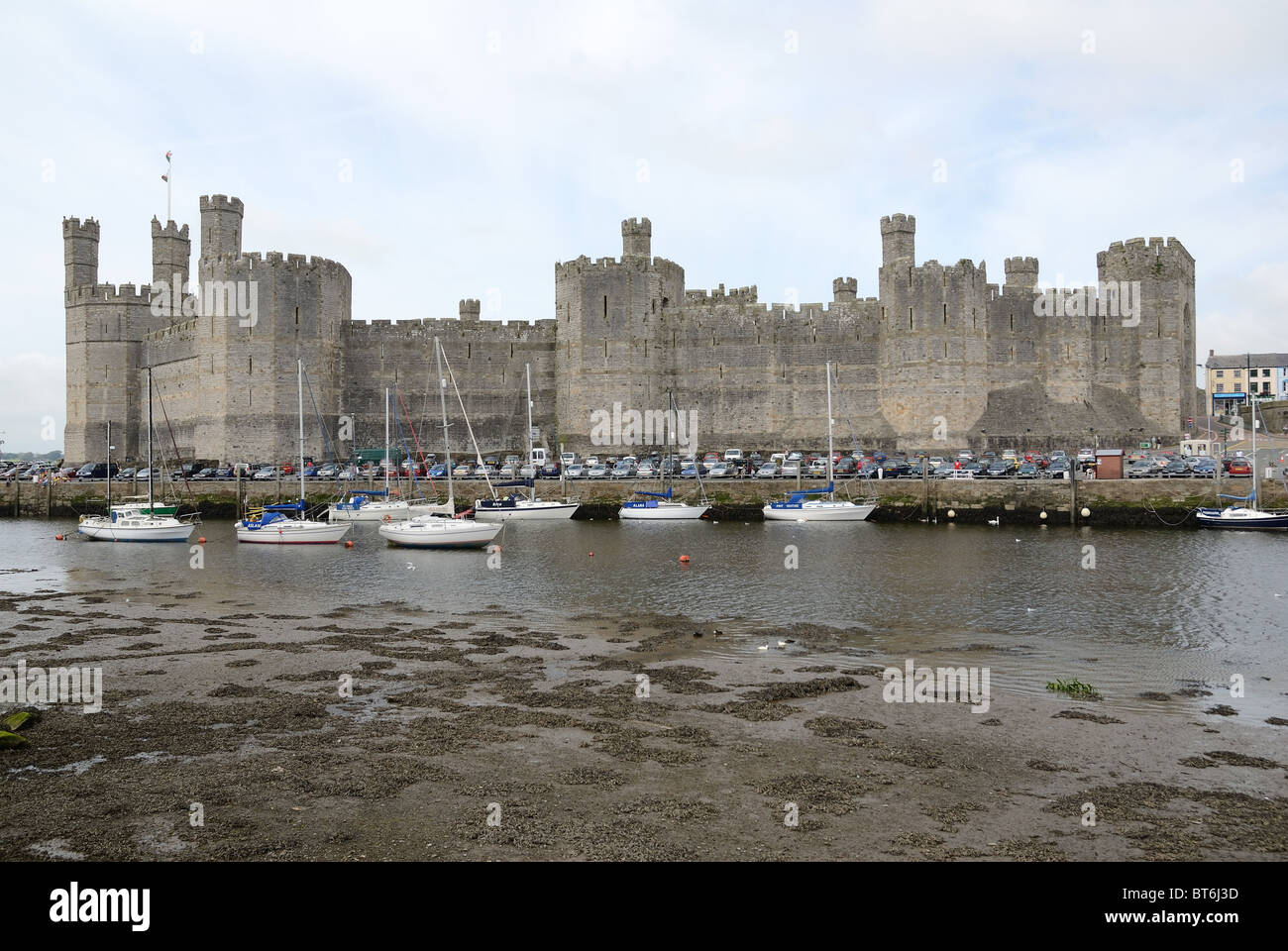 Yachts and other boats moored on the Seiont River at low tide in front of Caernarfon Castle North Wales Stock Photo