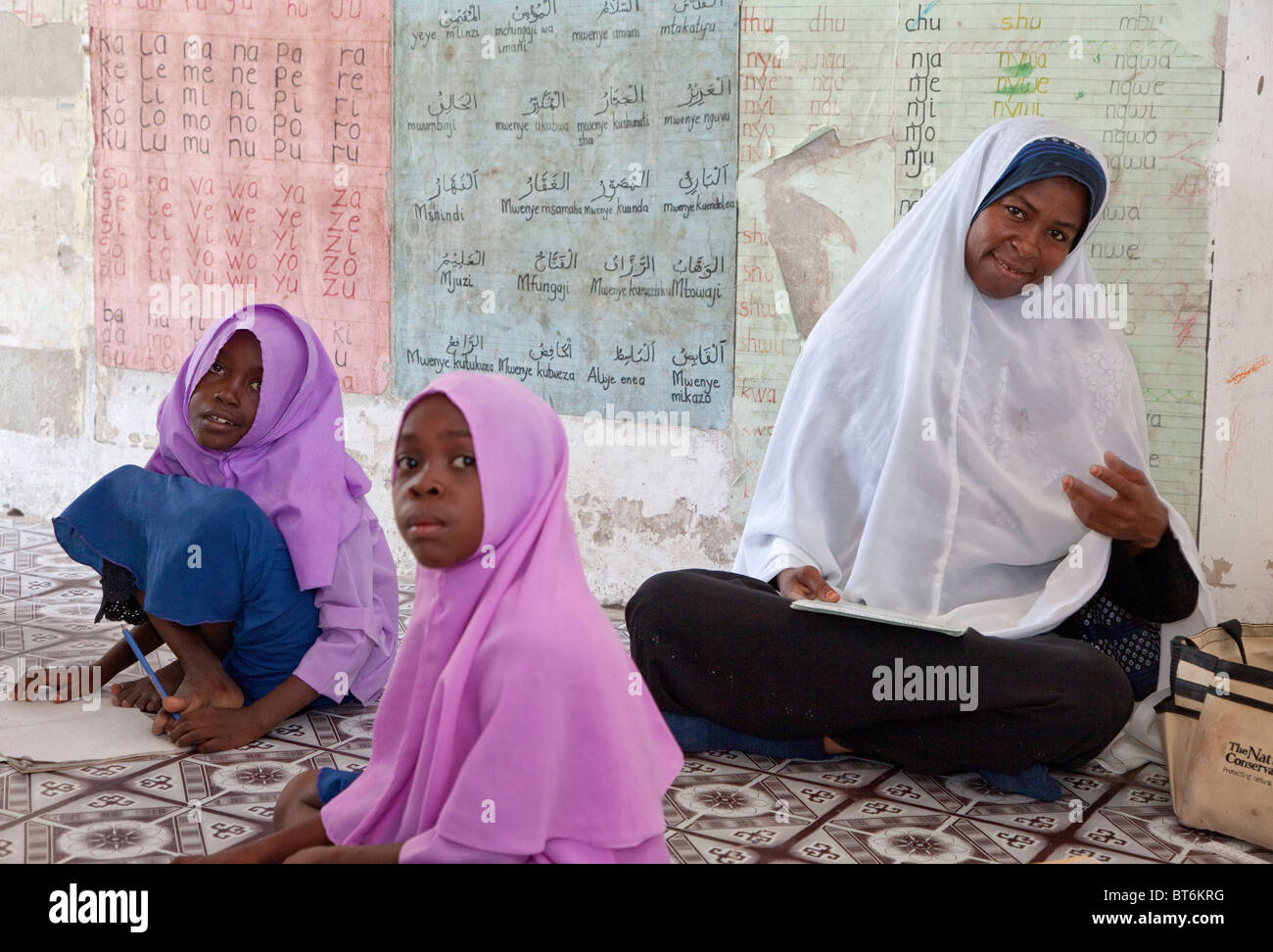 Jambiani, Zanzibar, Tanzania. African Muslim Primary School Teacher and Two Students. Stock Photo