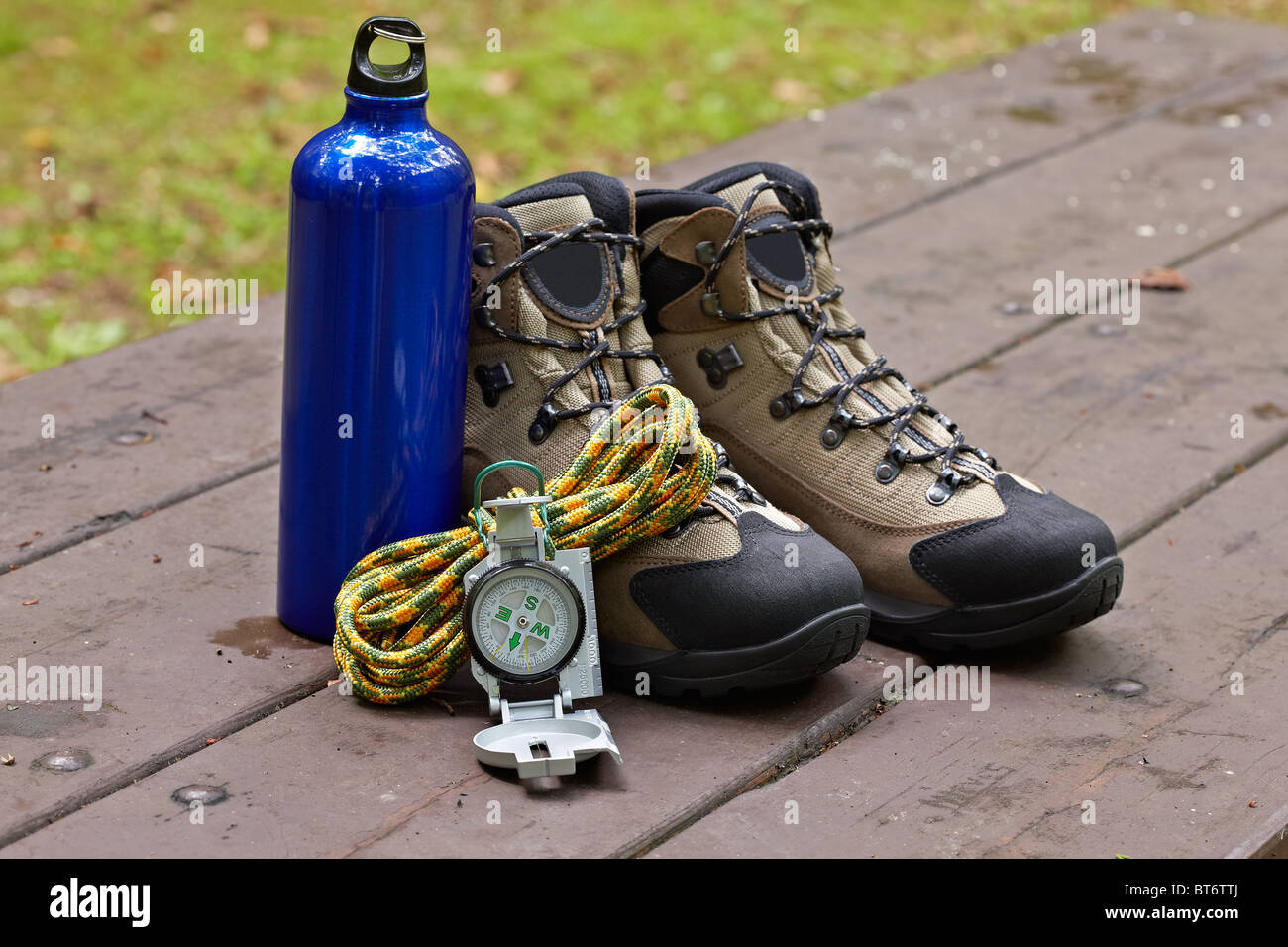 Hiking boots, canteen and compass in the table. Shallow depth of field and blurred background