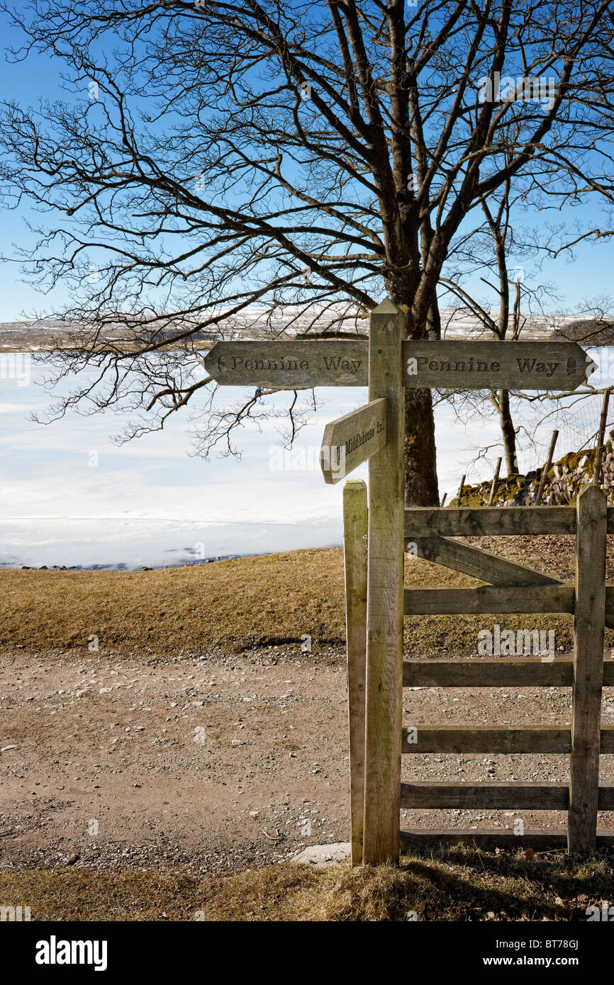 Pennine Way signpost by a frozen Malham Tarn, North Yorkshire Stock Photo