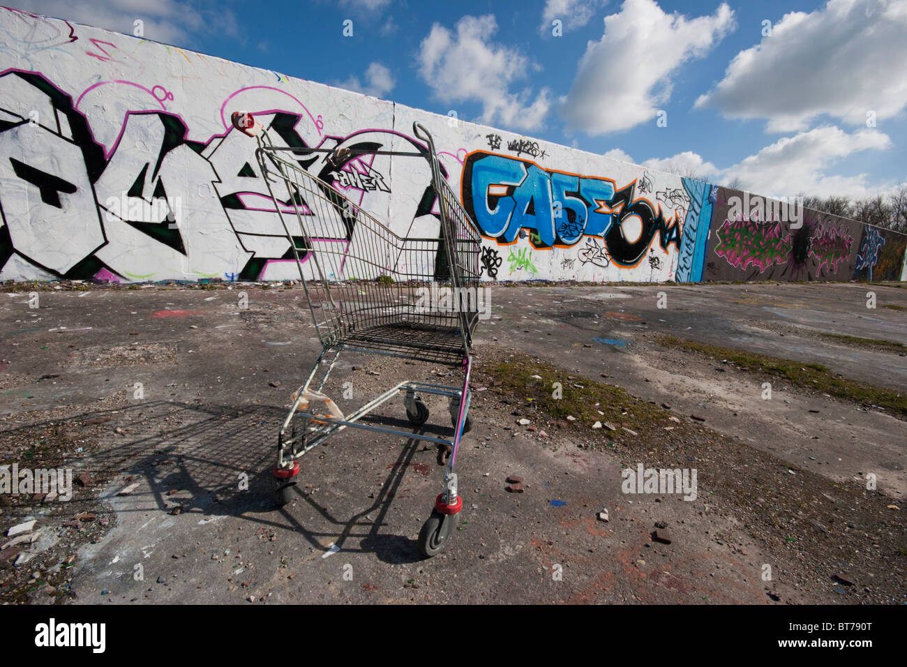 shopping trolley in front of graffiti wall in run down area Stock Photo ...