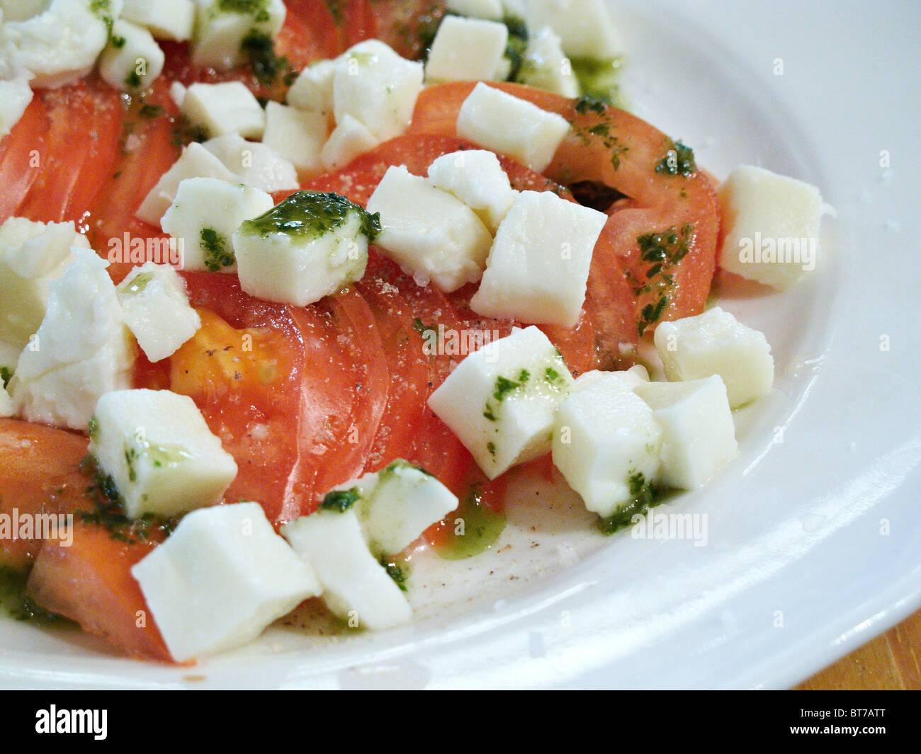 A traditional French appetizer with tomato, mozzarella and pesto served