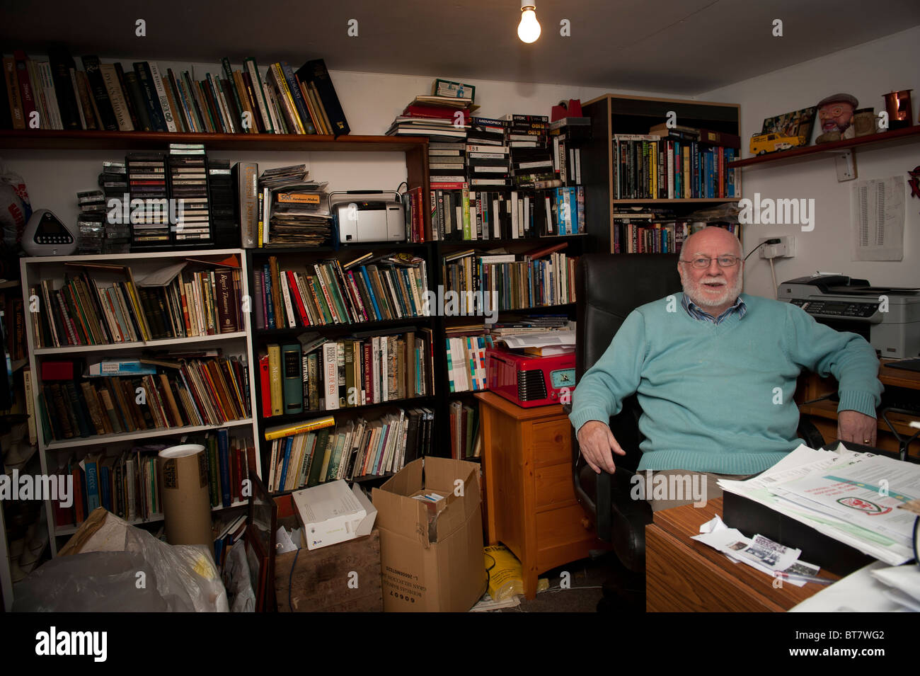 welsh language writer and humourist LYN EBENEZER sitting in his home