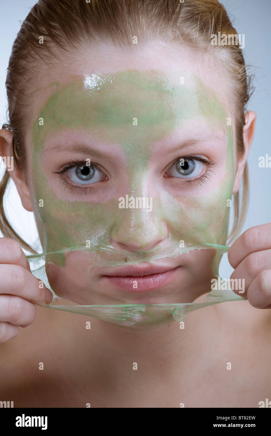 Young woman peeling off a facial mask Stock Photo