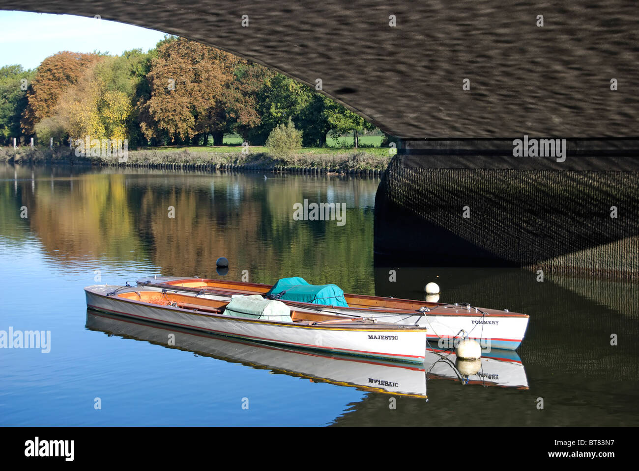 two small boats moored on the river thames beneath twickenham bridge, richmond upon thames, surrey, england Stock Photo