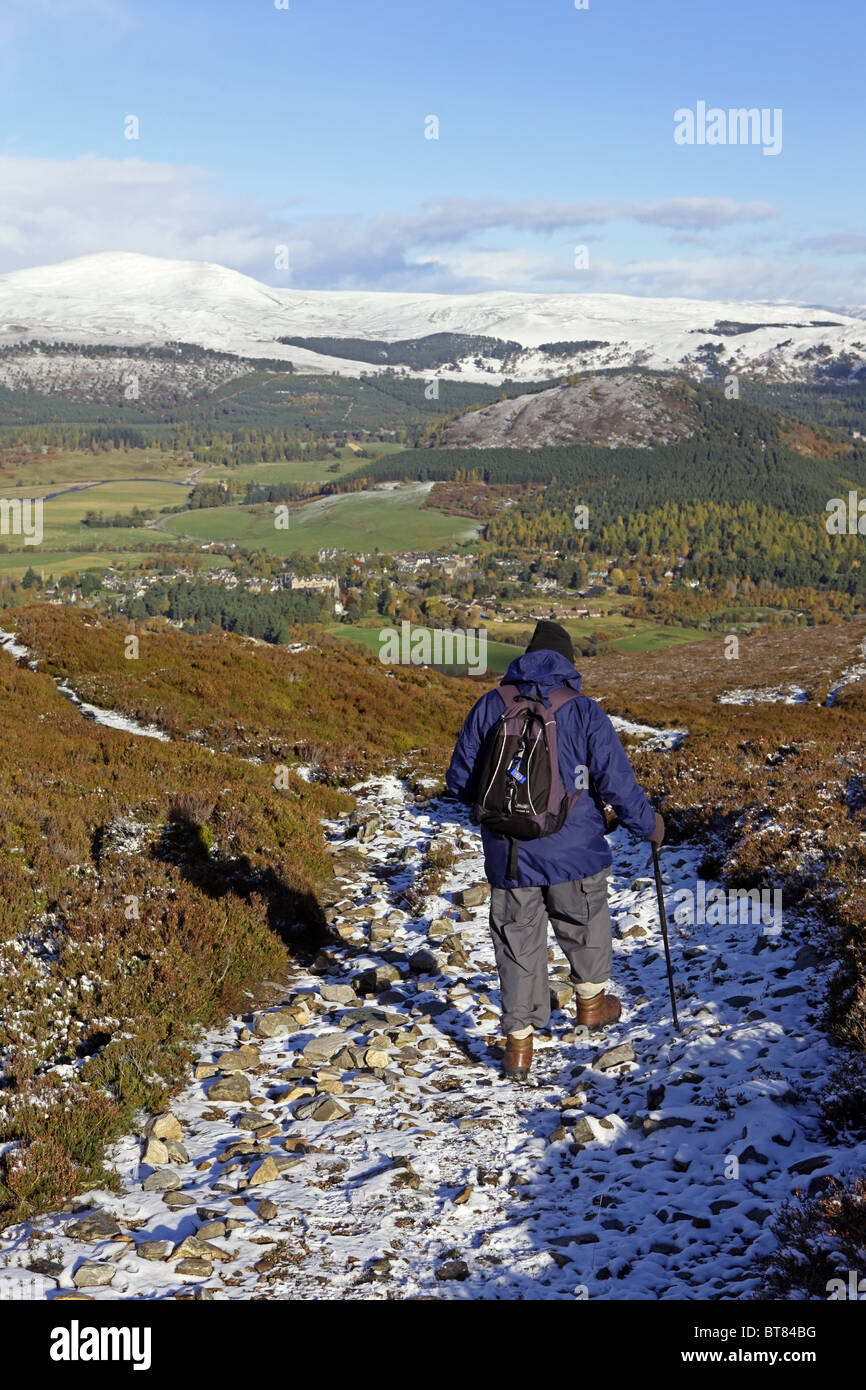 A walker descends towards the village of Braemar, Aberdeenshire, Scotland, from the summit of Morrone or Morven Stock Photo