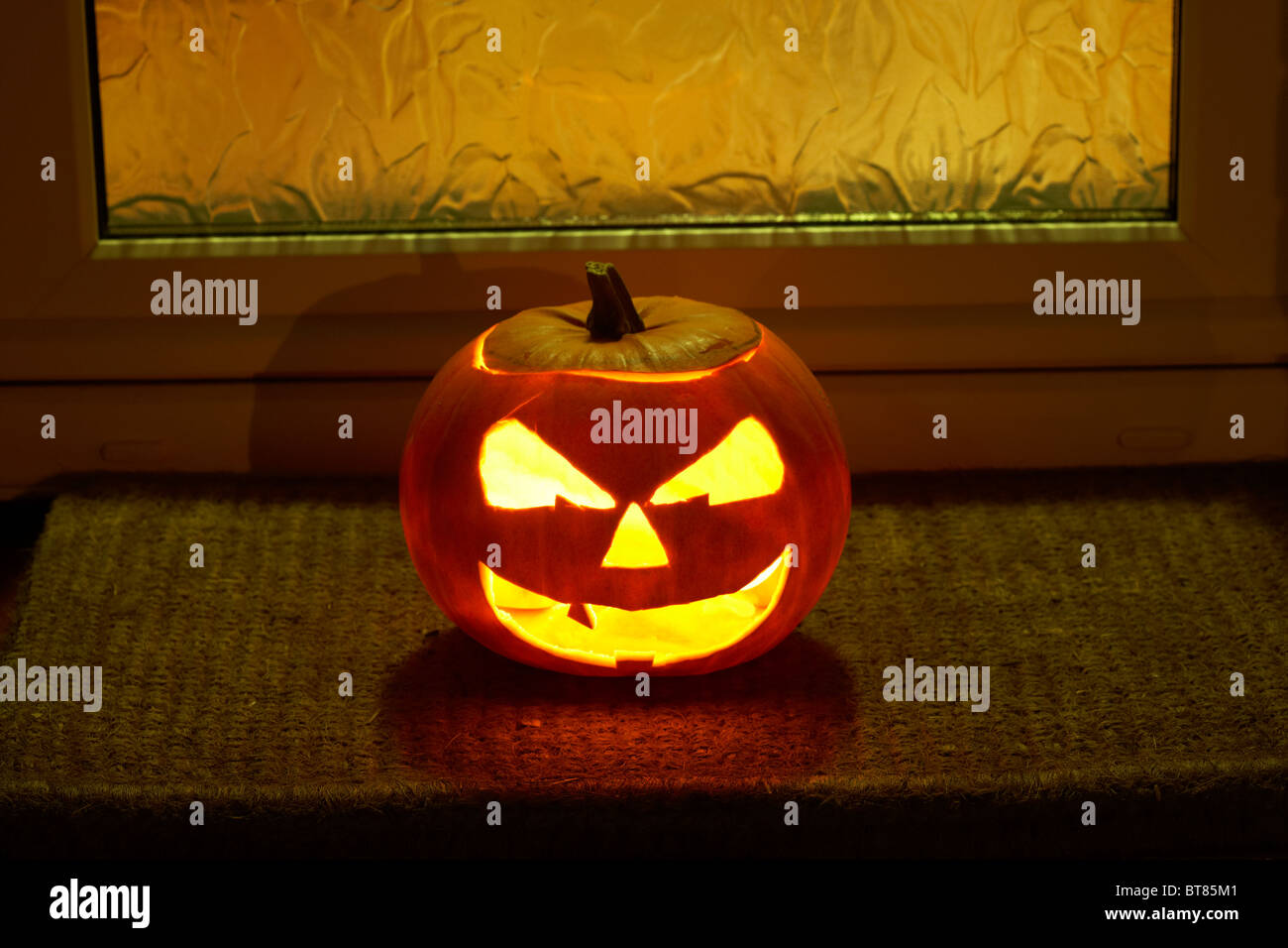 illuminated halloween pumpkin jack-o-lantern outside a house to ward off evil spirits Stock Photo