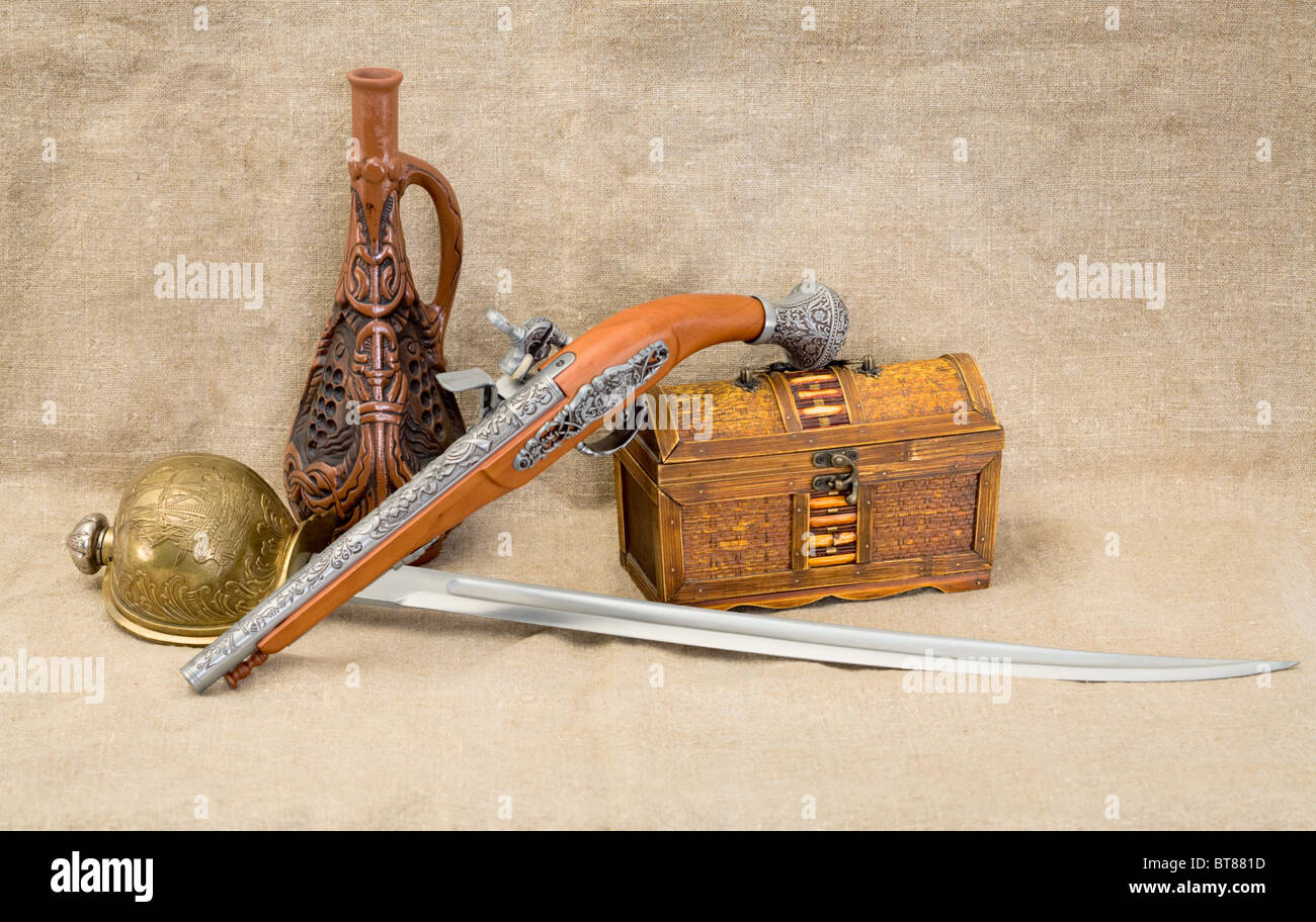 Still life with bottle, rapier, sword, pistol and chest Stock Photo