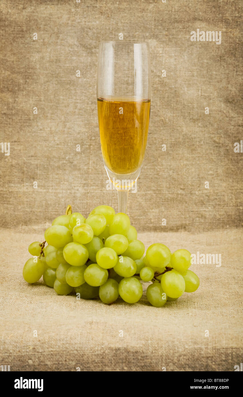 Goblet and green grape on sacking background Stock Photo
