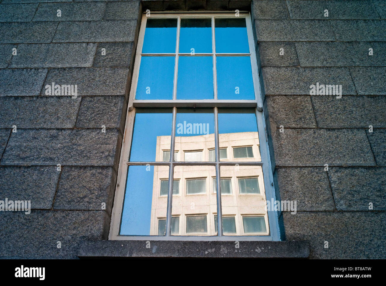 A reflection of the old motor tax building in a window of the Bridewell ...