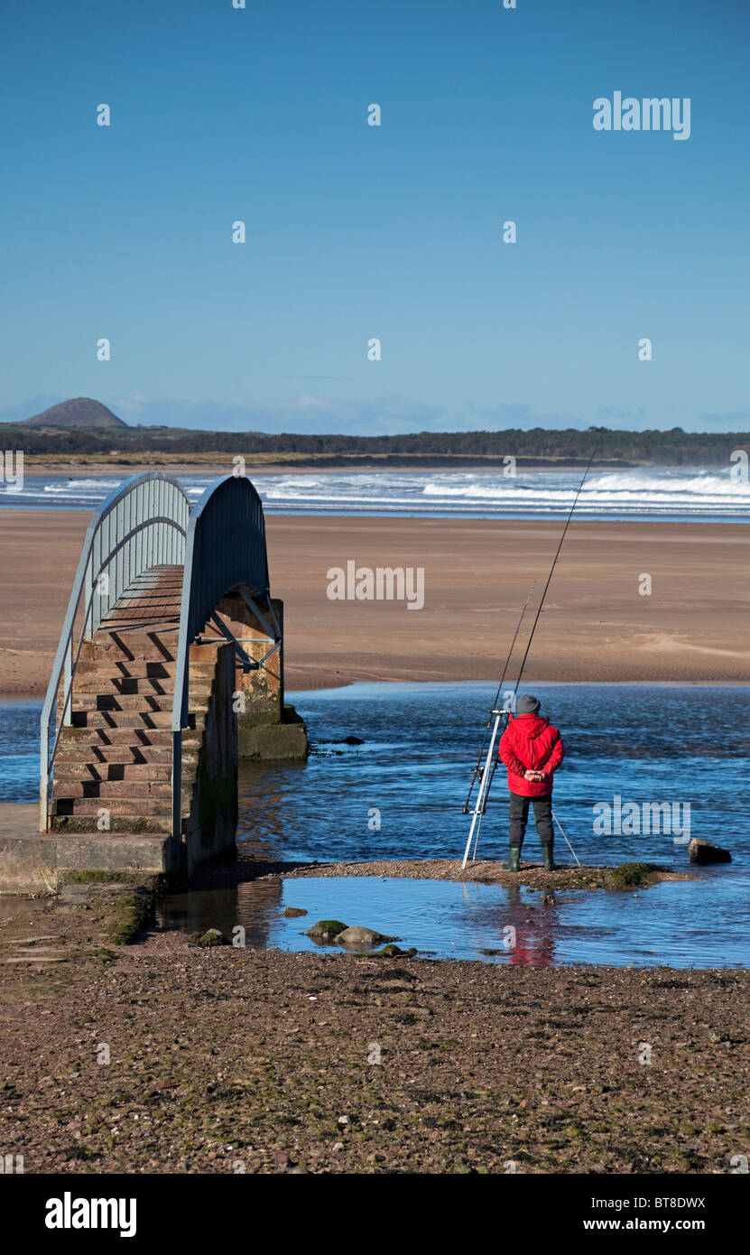 Man in red jacket fishing Belhaven Beach, East Lothian Scotland, UK, Europe Stock Photo