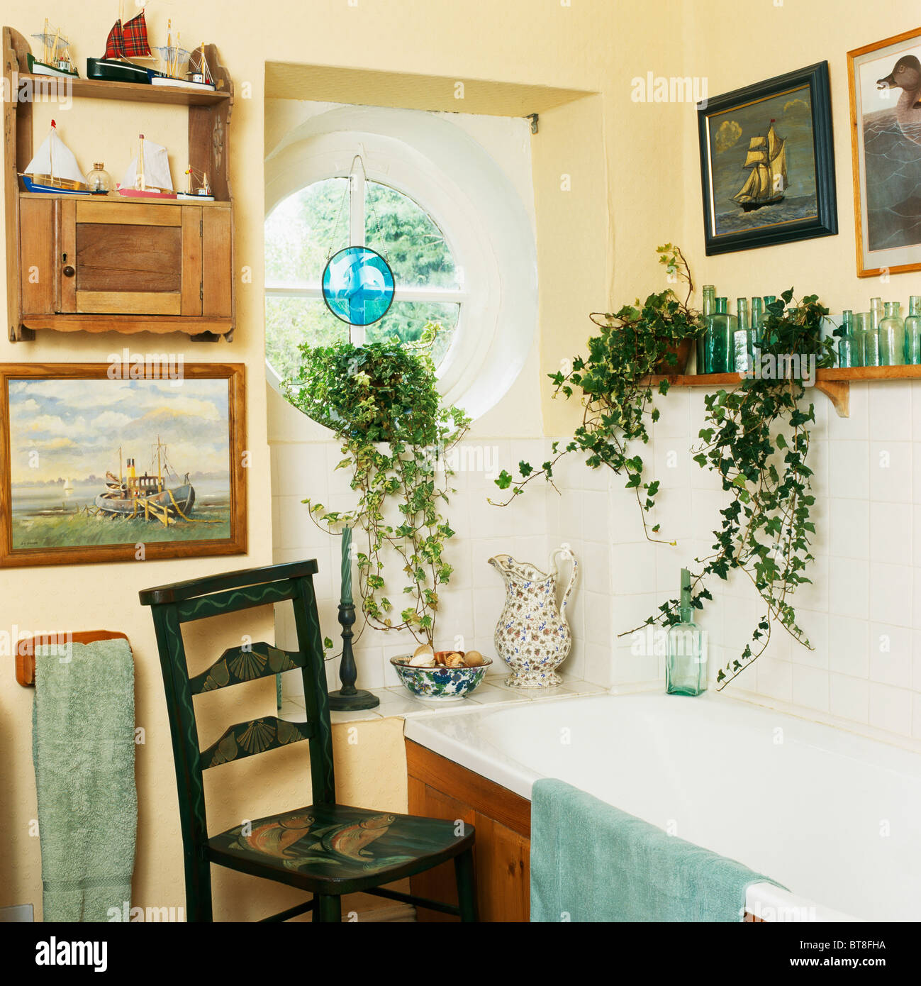 Trailing green houseplants on shelf above bath in small cottage