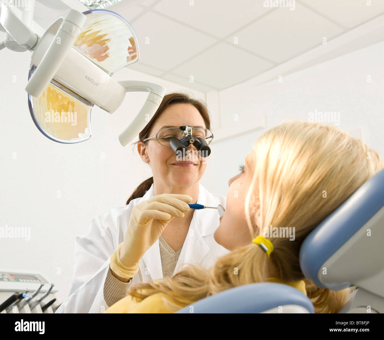 Dentist wearing magnifying glasses, treating a dentist Stock Photo