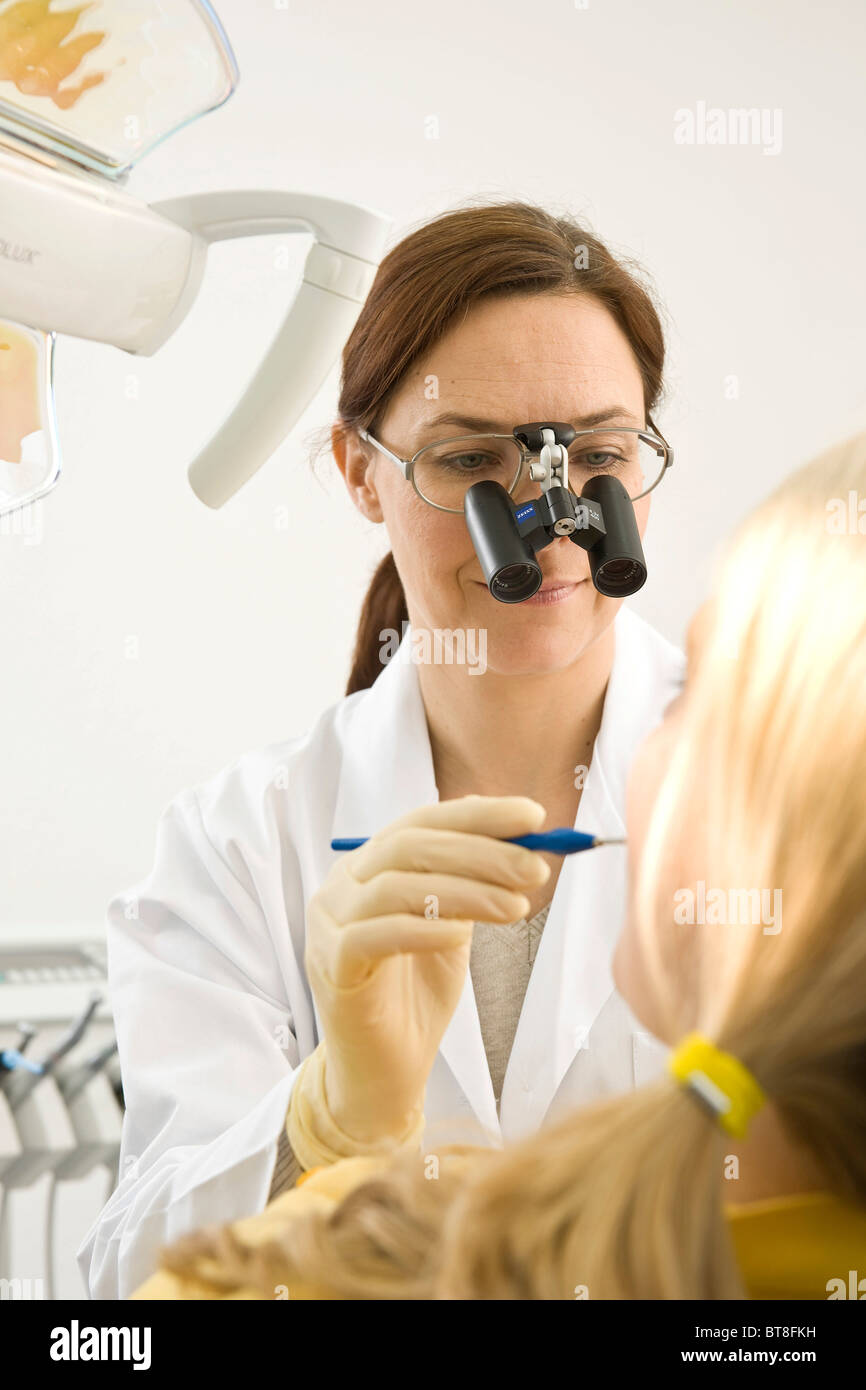 Dentist wearing magnifying glasses, treating a dentist Stock Photo Alamy