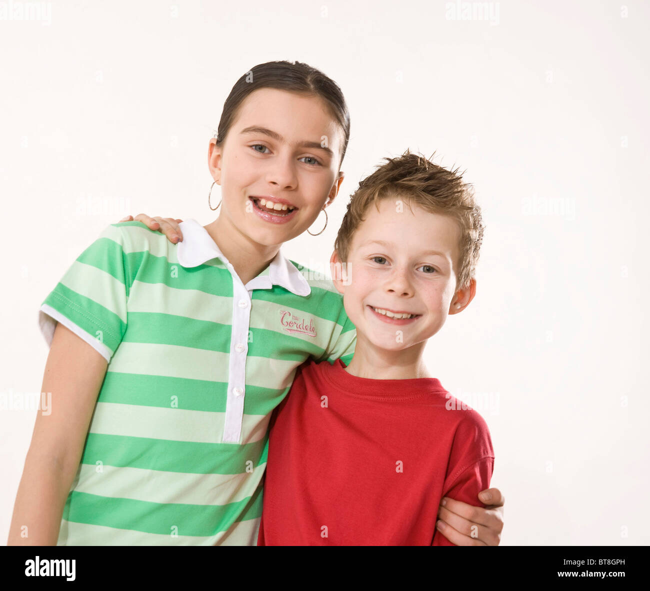 Potrait of a smiling boy and a smiling girl, holding each other arm in