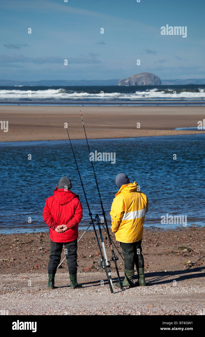 Two men sea fishing Belhaven Bay Beach, East Lothian Scotland, UK