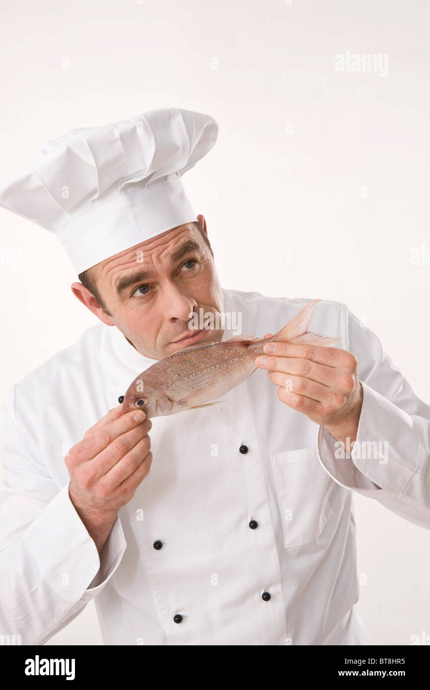 Cook smelling a fish Stock Photo Alamy