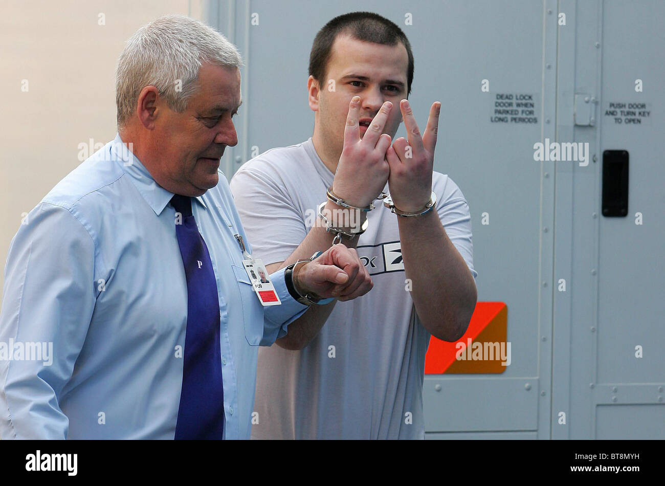 An unnamed prisoner gestures as he's led into Lewes Crown court in handcuffs. Picture by James Boardman. Stock Photo