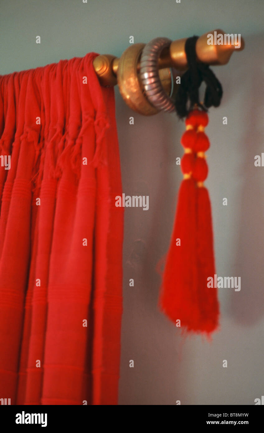 Close Up Of Red Velvet Curtain And Tassel On Wooden Curtain Pole