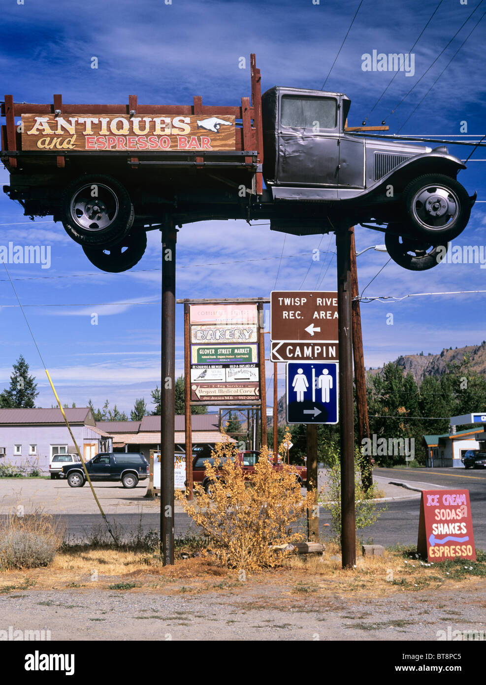Twisp, Washington State, USA. OLD TRUCK RAISED on posts and other advertisements in a small town