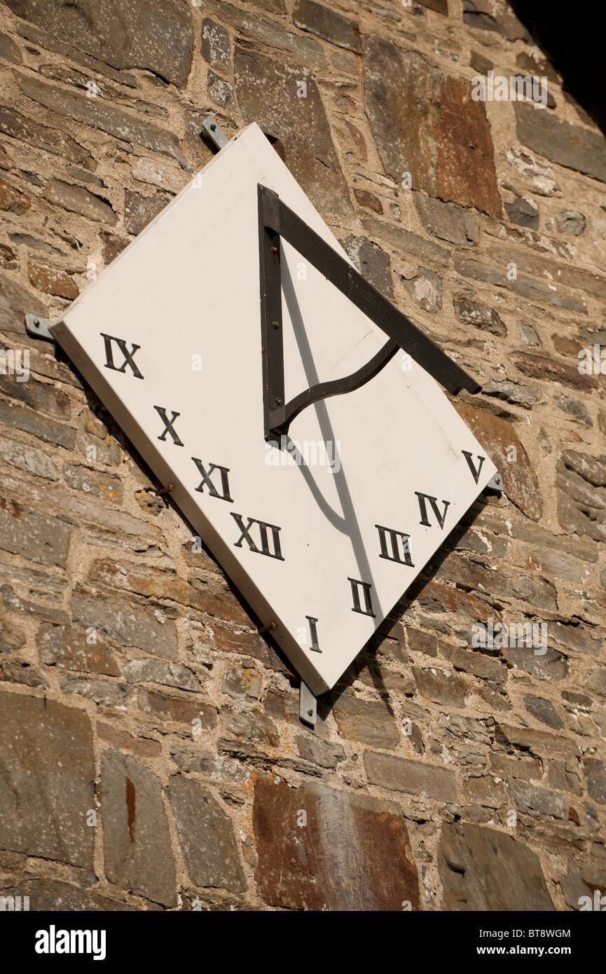 A simple Sundial gnomon casting a shadow on style plate on the outside of the church in Llanfihangel y Creuddyn Wales UK Stock Photo